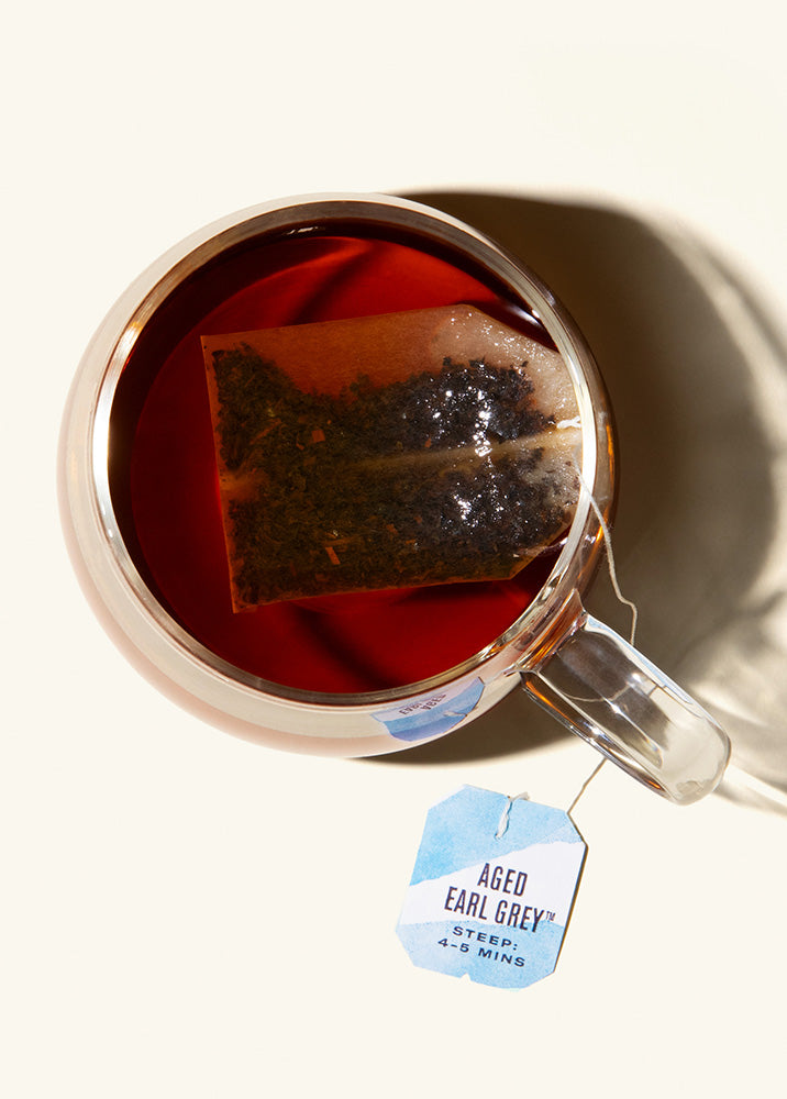 A cup of Numi Aged Earl Grey tea on a cream background